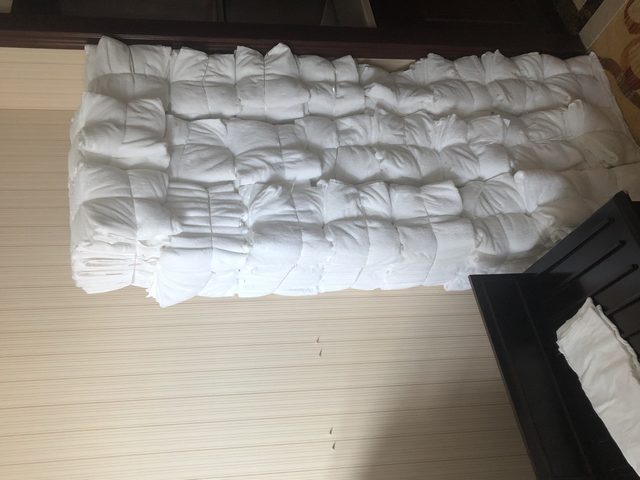 酒店装修换新布草回收现场白色床品被芯堆叠